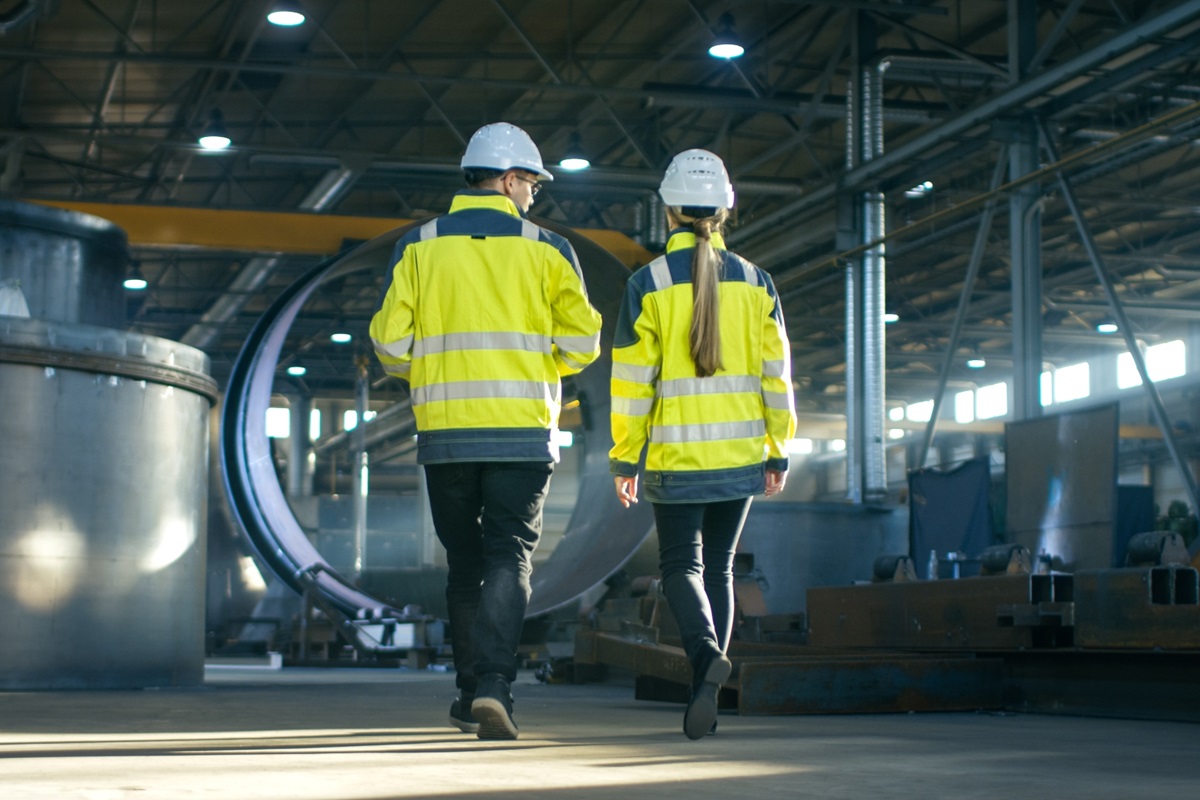 Man and woman walking in industrial hall
