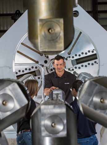 Three Sulzer employees are repairing a very big turbine rotor