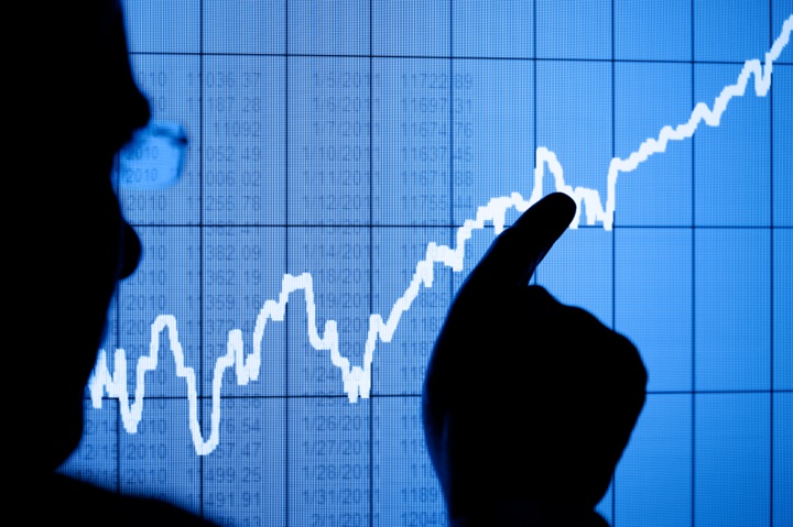 Man pointing on a stock market information with his finger