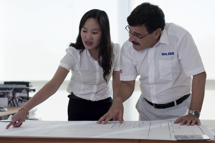 Two Sulzer employees examining a plan