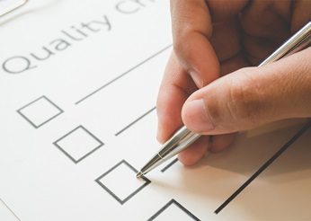 Pen ticking a box on a quality checklist