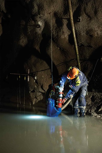 Man is using dewatering pump in cave