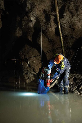 Man is using dewatering pump in cave