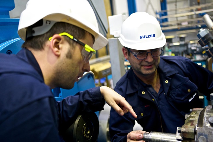 Two engineers repairing a pump