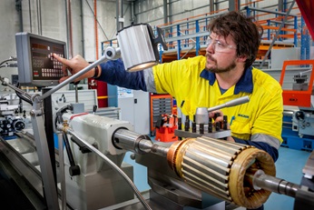 Employee working on small motor stator.