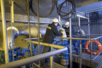 Men are installing pump in wastewater pumping station