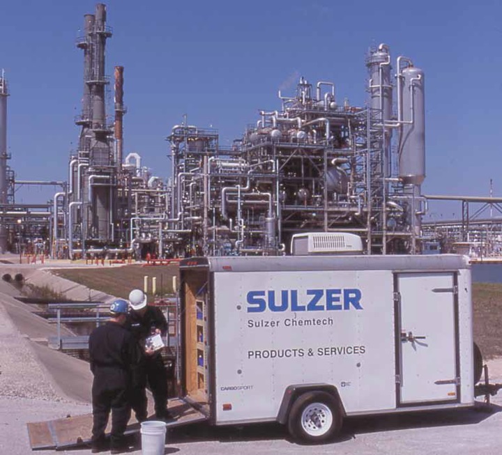 Two Sulzer Chemtech employees with a trailer in front of a customer mill