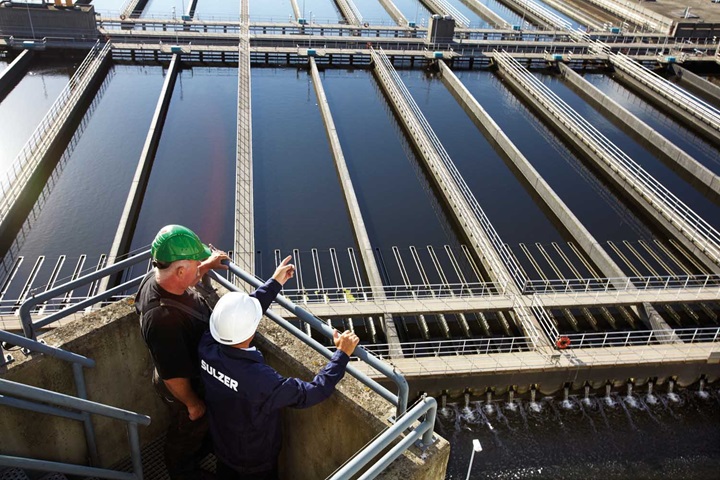 Sulzer employee and customer look out over wastewater treatment plant in Denmark