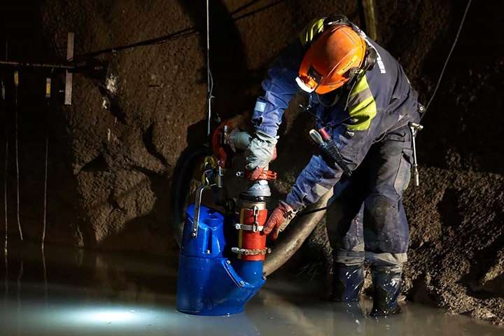Man installs a dewatering drainage pump XJ in a mine