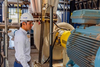 Man standing next to Sulzer's pump