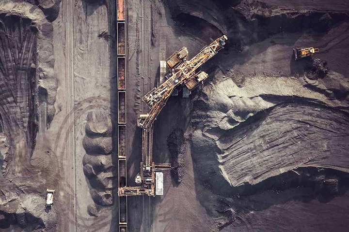 Areal shot of machines and train track in coal mine